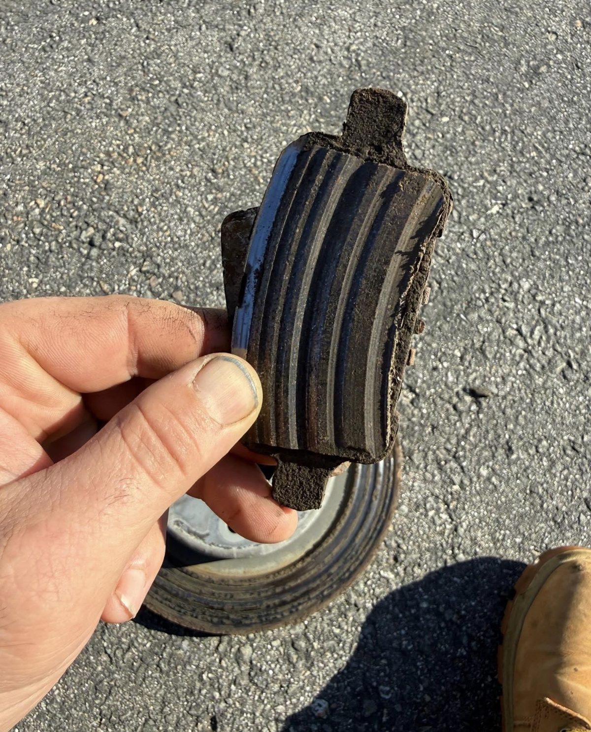 Completely worn-out brake pad removed during a mobile brake job, worn down to the metal
